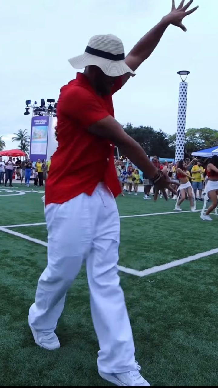 Pedro bailando en Fan Fest con camisa roja, pantalón y sombrero blancos